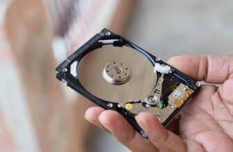 Person holding an open hard disk drive.